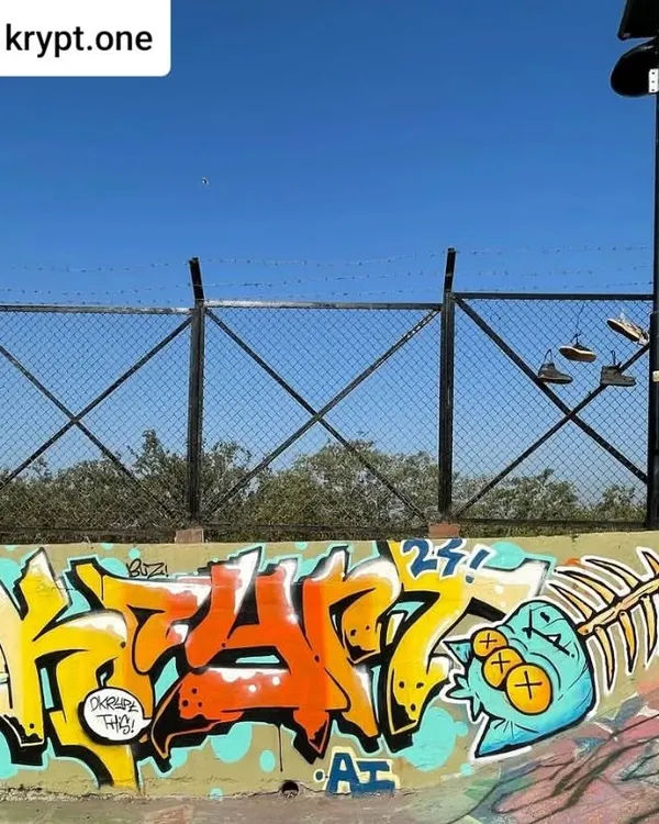 A classic graffiti piece by artist Krypt.one at the Carter Road Skate Park. The sharp, stylized lettering is paired with a cartoon fish skeleton, a perfect fit for the location.
