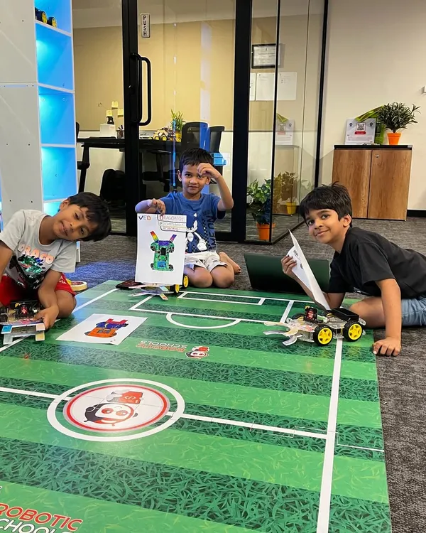 Here are three of my students proudly displaying their custom-designed soccer robots. They are all set for the competition, ready to put their building and programming skills to the test on the field.