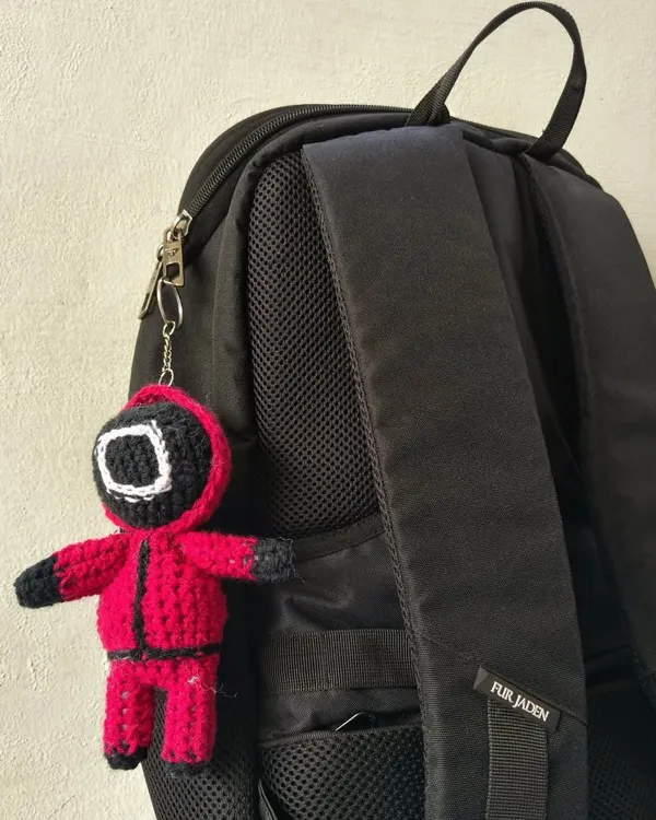 My Squid Game guard keychain attached to a backpack. It's a great way to show off your favorite show and add some personality to your gear.