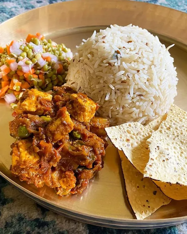 A balanced and wholesome meal on a single plate. This features my biriyani masala with paneer, served with caramelised rice, a fresh sprout salad, and crispy papad.