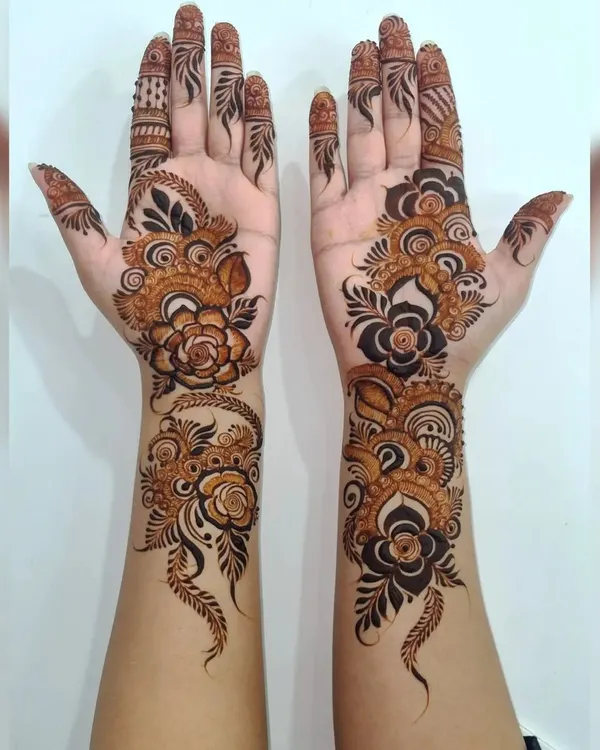 For a modern and bold statement, I love creating Arabic-style henna. This design features prominent floral vines that flow elegantly along the hands, leaving open space to make the pattern pop.