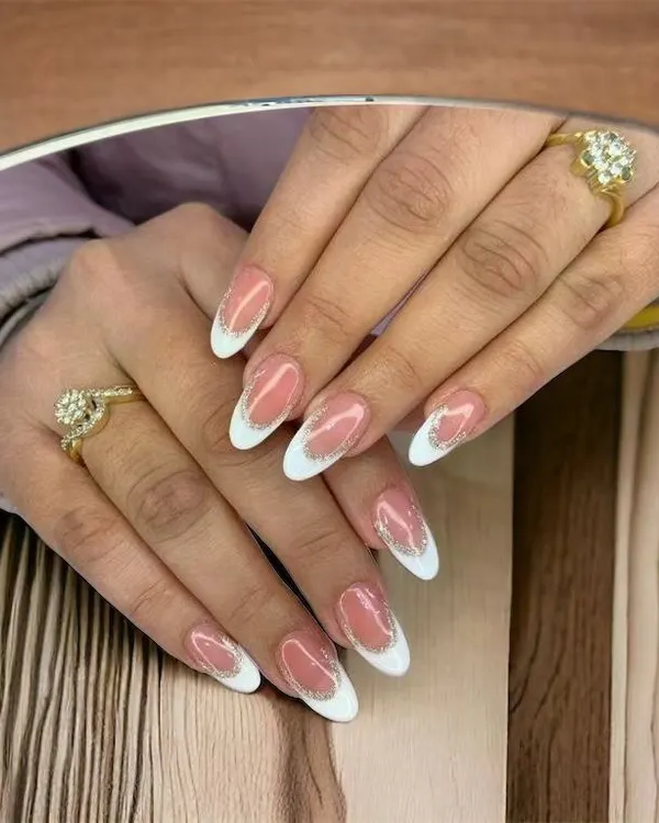 This is my take on the timeless French manicure, done on elegant almond-shaped nails. I focus on creating a crisp, clean white tip and a perfectly shaped nail bed, finished with a subtle glitter line for a touch of sparkle. This is a popular choice for a sophisticated, everyday look.