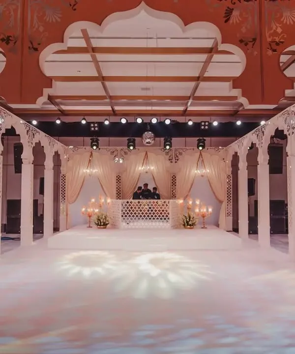A wide view of the palatial stage we constructed, complete with a pristine white dance floor. The design was centered around tall, standing arches to enclose the space and create the feel of a royal courtyard.