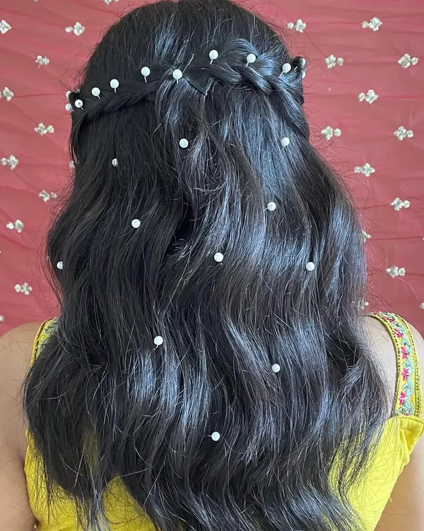 A detailed view of this beautiful half-up hairstyle with pearls scattered through the waves. This is a romantic and popular choice for bridesmaids and wedding guests.