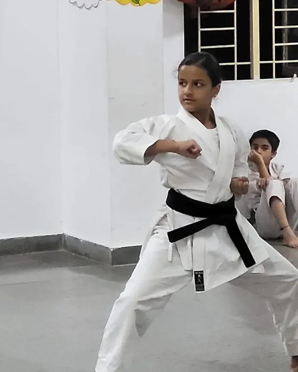 A young black belt student demonstrates a powerful and focused stance, embodying the discipline and skill we cultivate in all our karateka from a young age.