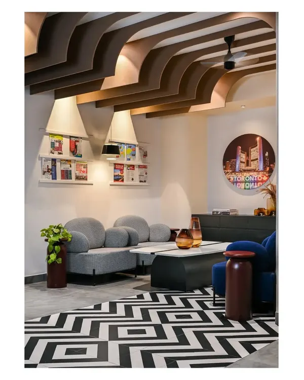 For the Centennial College office in Bangalore, we broke the barriers of a stereotypical work environment. The reception lounge uses bold geometric floor tiles, comfortable curved sofas, and unique ceiling fins to create a welcoming and dynamic first impression.