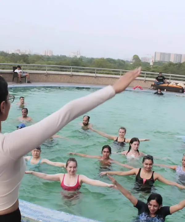 Welcome to my practice. Here I am leading an Aqua Yoga session, a unique style that combines the gentle resistance of water with mindful yoga postures. It's a fantastic low impact workout that improves flexibility, strength, and balance, making it perfect for everyone.