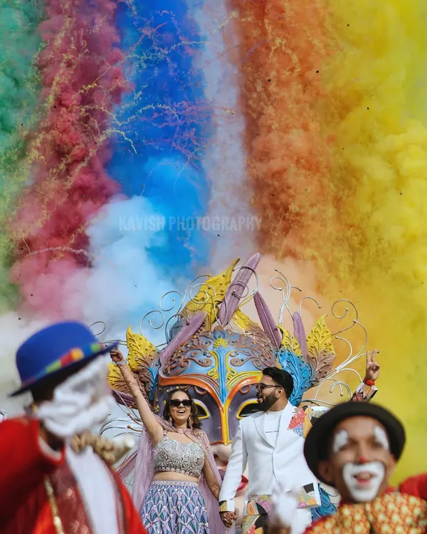 A vibrant and energetic couple's entrance, framed by performers and a burst of colorful smoke. This is the kind of high-energy, celebratory wedding photography I love to capture.