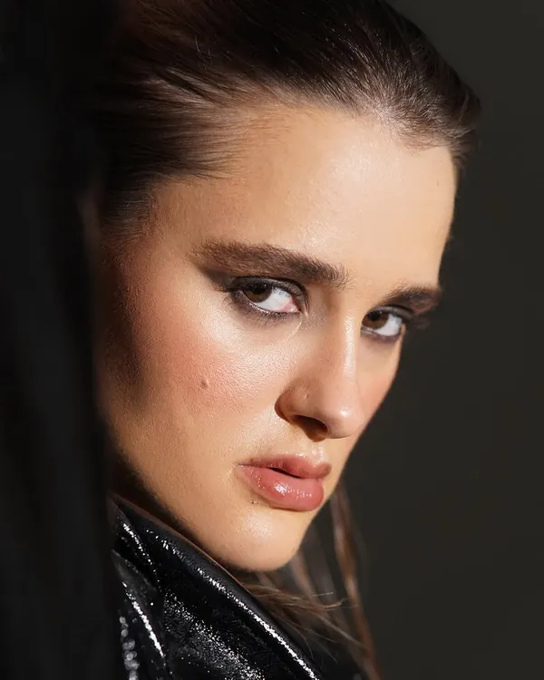 An intense and intimate close up of a graphic smokey eye. The sharp lines and deep pigment create a powerful, high fashion look, balanced by glossy, nude lips and naturally glowing skin.