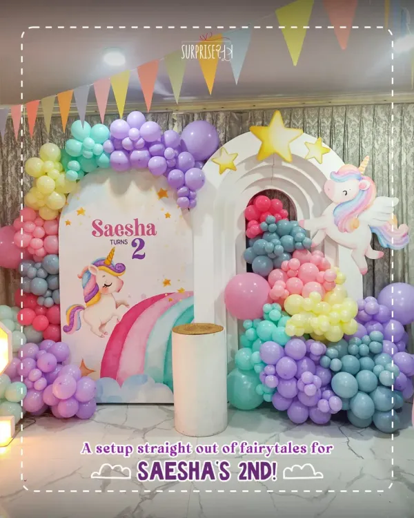 A setup straight out of fairytales for Saesha's 2nd birthday! This unicorn-themed backdrop with rainbow pastel balloon arches and a light-up number '2' was pure magic.