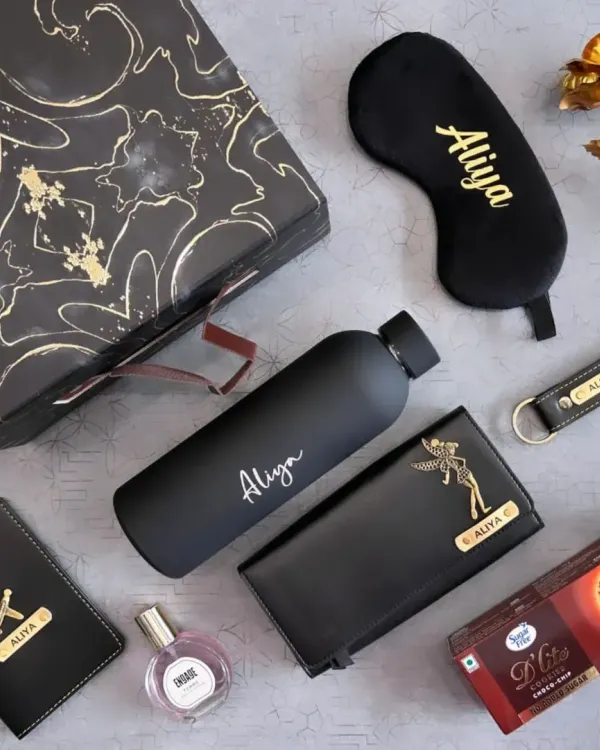 This all-black themed gift set for her is the definition of chic. It includes a personalized water bottle, clutch, passport holder, keychain, and eye mask, plus perfume and cookies, all elegantly arranged.