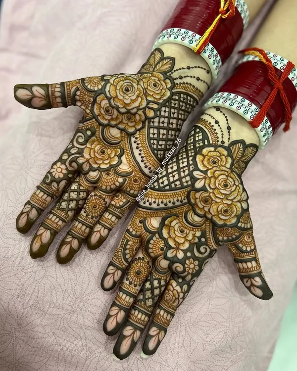 A beautiful example of modern floral henna. This design features bold, shaded roses on the palms with a delicate jaali pattern, leaving some open space for a contemporary feel.