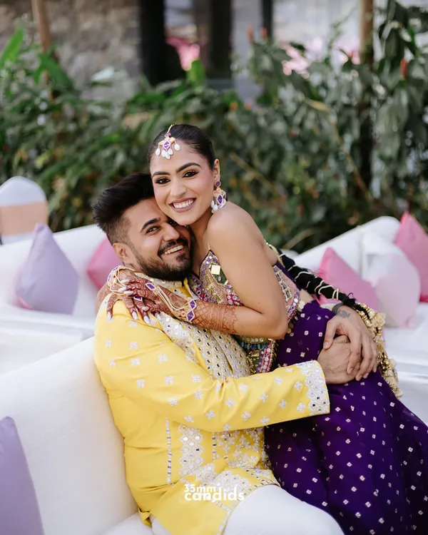 A joyful, candid hug between the couple during their mehendi ceremony. Their bright outfits and even brighter smiles capture the fun and festive spirit of the day.