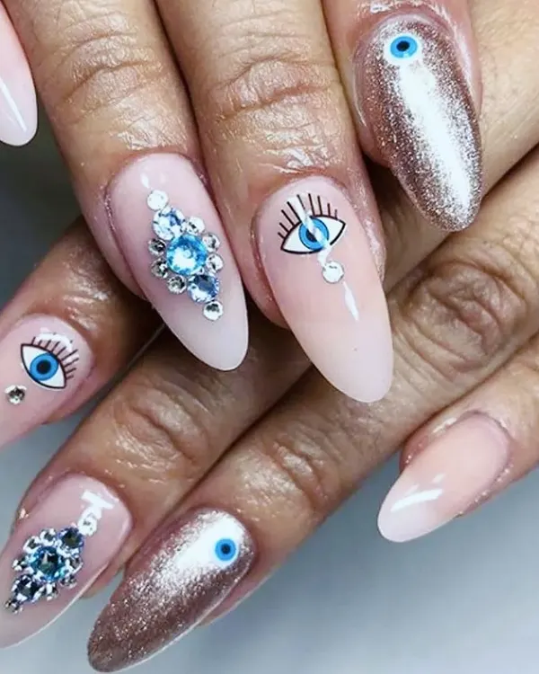 A perfect example of detailed custom work. These almond gel extensions feature hand-painted evil-eye art, a full coverage chrome glitter nail, and precisely applied blue crystal clusters for a truly unique and protective design.