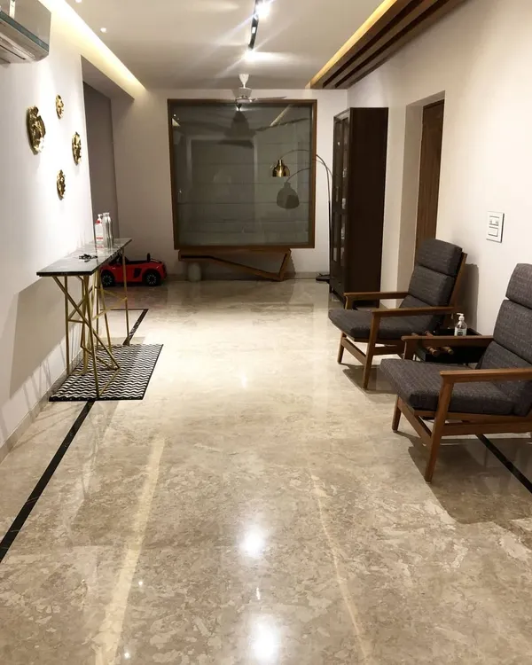 The entrance foyer of a residential project in Hyderabad. We designed the sleek console table with a geometric gold base and a pair of comfortable wooden armchairs to create a welcoming space.