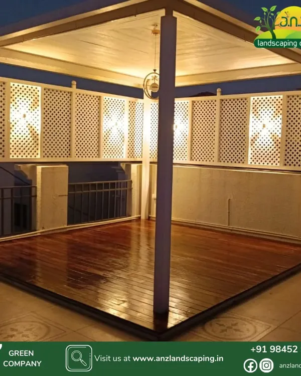 This is the same white gazebo from a different angle, showing the beautiful wooden deck flooring and warm interior lighting. This structure is perfect for creating a defined, semi-private seating area on any rooftop.
