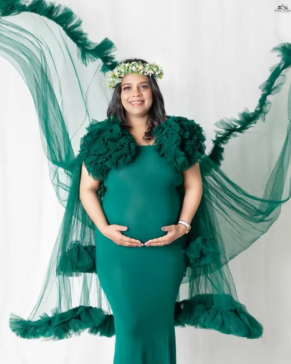 A full-length portrait showcasing our beautiful flowing green gown. The way the fabric drapes and flies creates such a dreamy effect. This is a perfect choice for moms who want a touch of drama in their maternity photos.