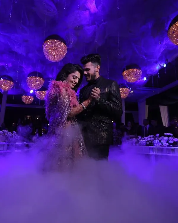 A couple's romantic first dance on a cloud of low-lying fog under a canopy of purple light and hanging crystal orbs. I use atmospheric effects to create truly magical moments for your reception.