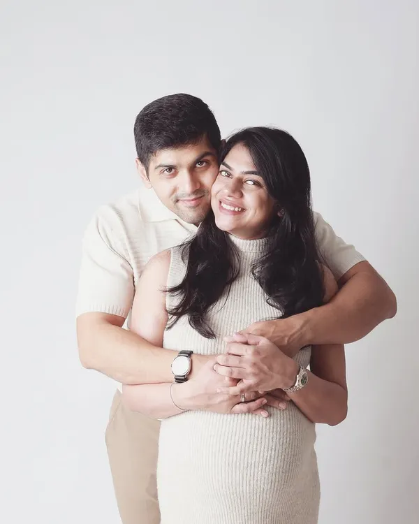 A warm embrace from behind, a classic pose that feels safe and full of love. This is a perfect shot to capture the support and partnership you share on this journey.