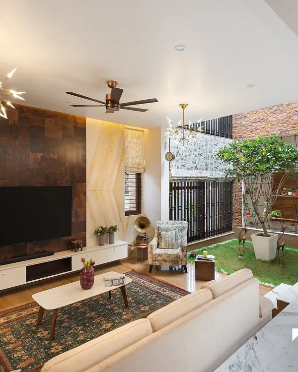This living space from our Twin Courtyard project embodies our core design philosophy. We opened the room to a lush, green central courtyard, flooding the interior with natural light and creating a seamless connection between the home and nature for a truly soulful living experience.