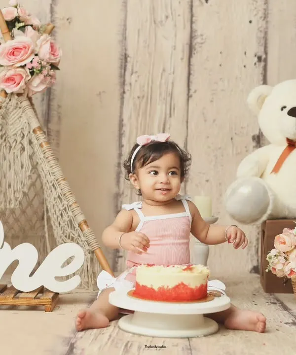 A perfect setup for a first birthday cakesmash. This boho-themed scene includes a miniature teepee, a teddy bear, and the 'One' sign, ready for the birthday girl.