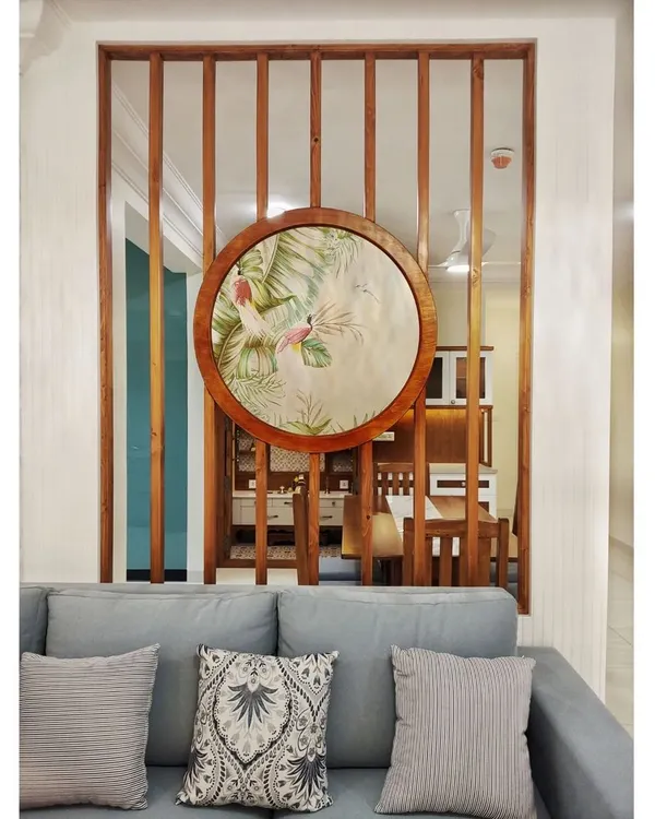 This living room in #TheDivinityHome is designed for effortless elegance. The custom wooden partition with inlaid art serves as a stunning focal point, separating the living and dining areas without closing off the space.