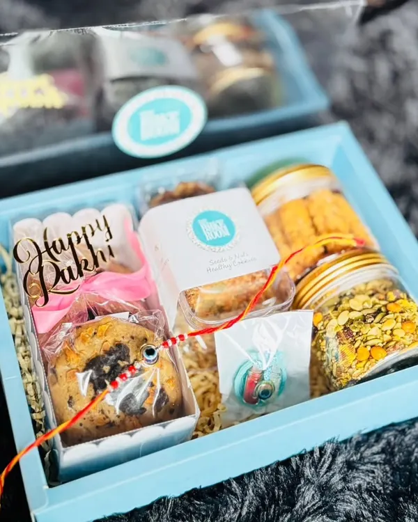 A beautiful Rakhi hamper packed with a variety of our treats. This box includes cookies, savory snacks, and a "Happy Rakhi" chocolate bar, making it a complete gift for your sibling.