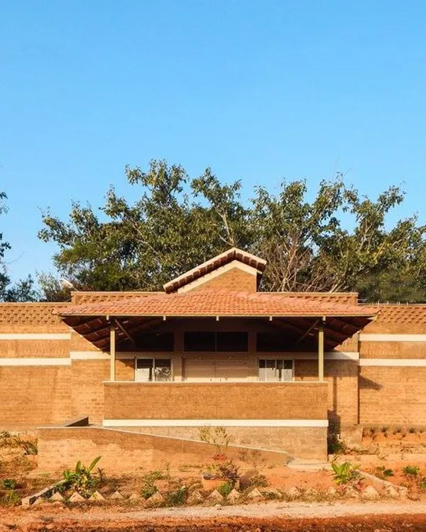 This building demonstrates the principle of emphasis, where the sloped Mangalore tile roof becomes a focal point. The structure is built with compressed stabilized earth blocks, showcasing how vernacular architecture can create visually striking and sustainable homes.