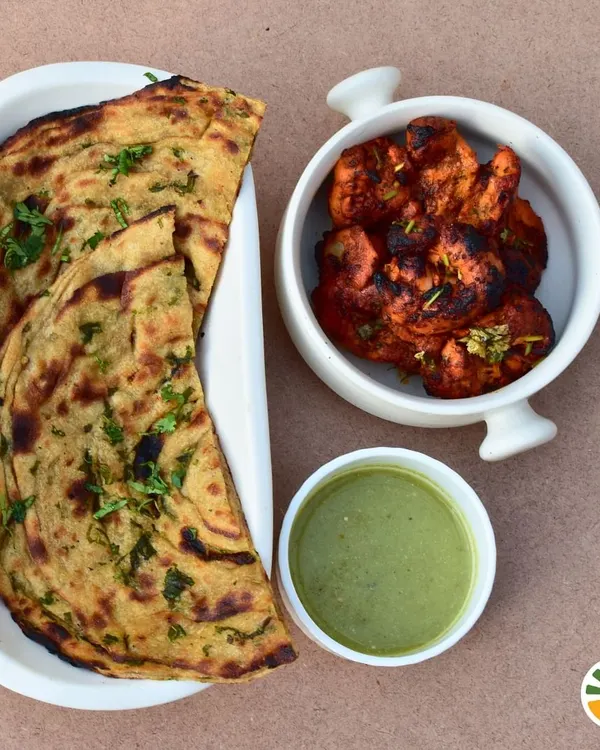 Here's a perfect winter dinner idea: smoky Tandoori Chicken served with a flaky Mint Laccha Parantha and refreshing mint chutney. It's a dish that's different yet feels incredibly homey.