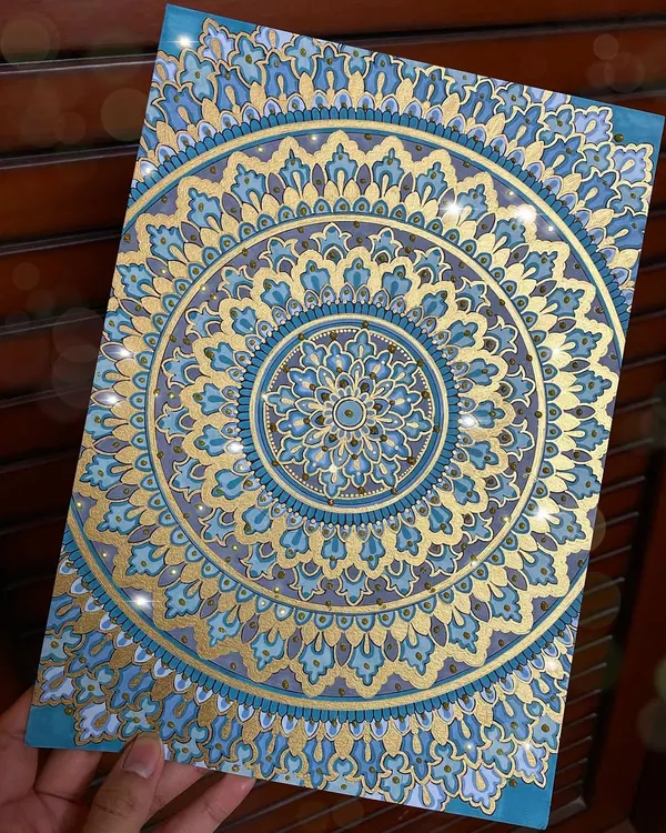 A full view of the detailed blue and gold mandala, created on A4 acrylic paper. The metallic gold paint catches the light beautifully, adding a touch of luxury to the intricate patterns.