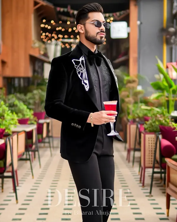 This black velvet blazer is the definition of luxury. It features intricate geometric embroidery on the lapels, creating a look that is both sophisticated and unapologetically modern for any formal event.