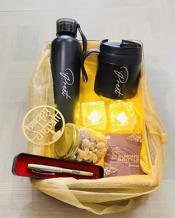 A complete Diwali hamper that blends modern and traditional elements. It includes a personalized bottle and mug, a pen, a jar of dry fruits, and electronic diyas, all beautifully arranged in a gift basket.