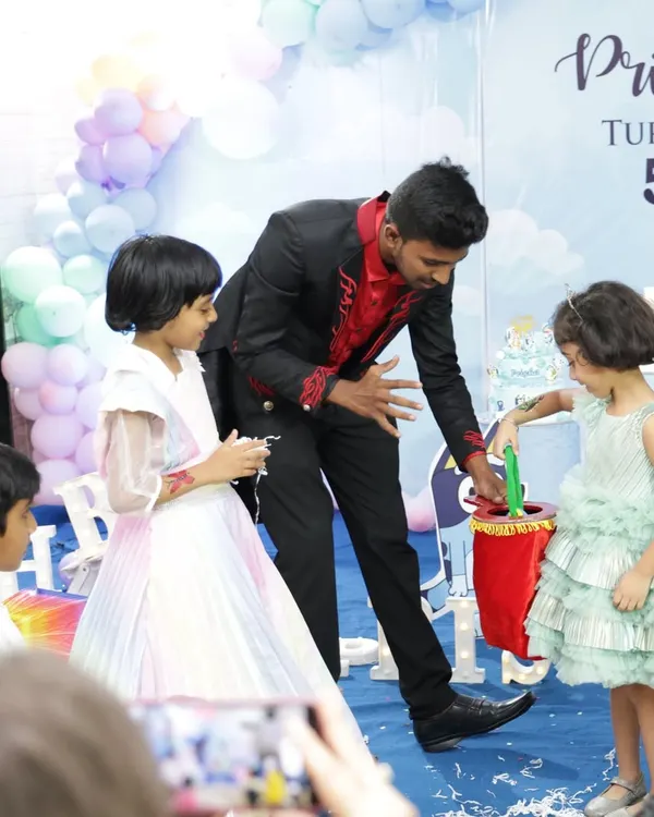 The best part of any kids' magic show is seeing them participate. Here, the birthday girl and her friend are helping me with a trick, pulling a surprise out of my magic bag.