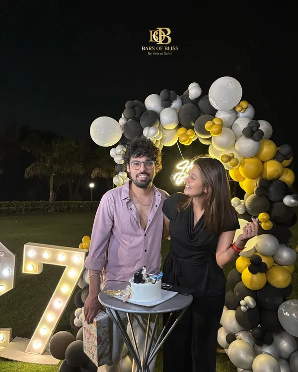 A happy client celebrating their 27th birthday with our decor. The outdoor setup with black, white, and yellow balloons and marquee numbers created the perfect backdrop for their special night.