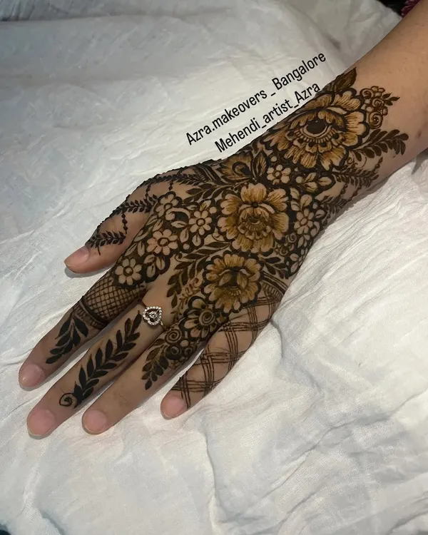 A perfect example of a classic Arabic mehendi design, featuring bold, shaded florals and leafy vines on the back of the hand.