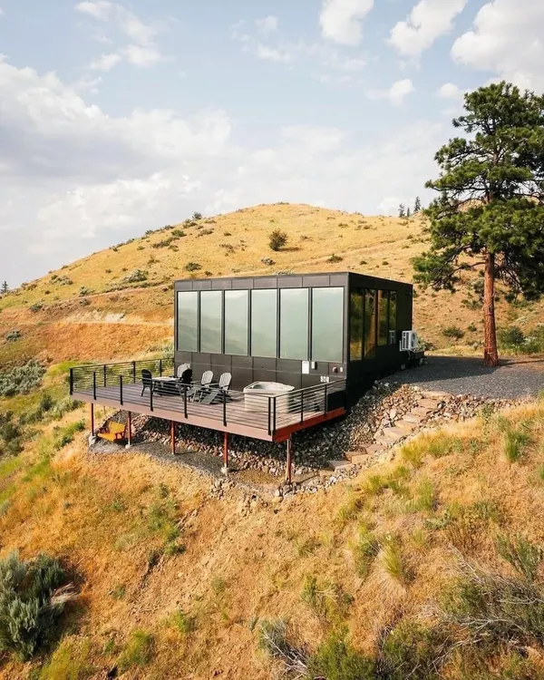 This is the pinnacle of modern modular living. A sleek, prefabricated home perched on a scenic hillside, offering breathtaking views and a minimal environmental footprint.