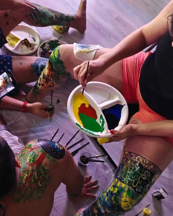 An overhead view of my body painting workshop. I provide all the materials and create a safe, non-judgmental space where participants can explore their creativity on a human canvas.