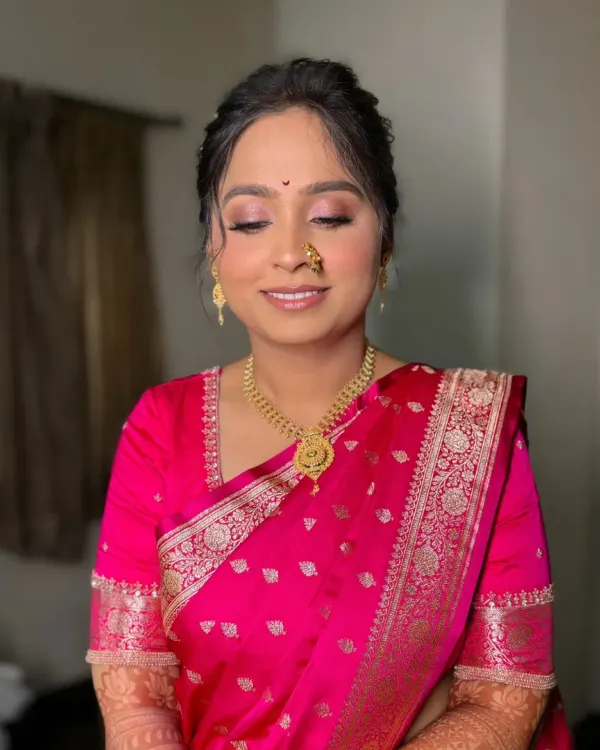 A serene bride on her engagement day. This look features soft pink eyeshadow, a flawless base, and a traditional 'nath', creating a perfect blend of modern and traditional.