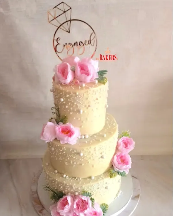 This grand three-tier engagement cake was a true showstopper. It traveled 60 km to the celebration, featuring three different delicious flavors to please every guest. I decorated it with delicate sugar pearls and fresh pink peonies for a classic, romantic look, all completely no-fondant.