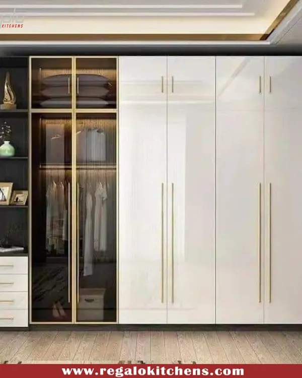 A perfect example of modern elegance. This wardrobe combines high-gloss white doors with a glass-fronted display section, complete with gold-finish handles for a touch of luxury.