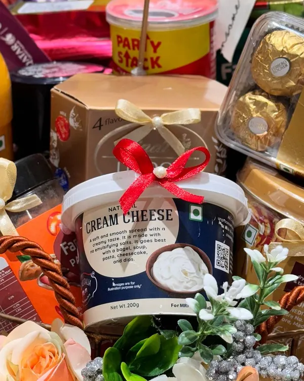 A close-up of a bespoke hamper curated for Qatar Airways. This shot highlights the premium products included, such as natural cream cheese and a Pringles Party Stack, demonstrating my ability to cater to luxury corporate clients.