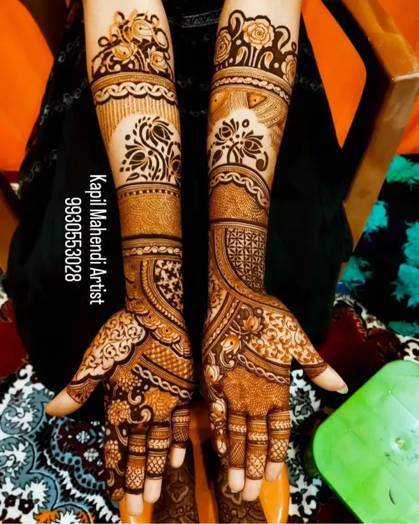 A classic full-hand bridal mehendi with a mix of floral and paisley patterns. The design is dense and intricate, providing a rich and traditional look.