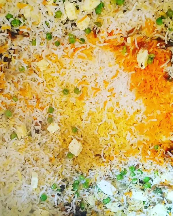 A top-down view of my delicious vegetable biryani, full of fresh peas, paneer, and fragrant saffron rice.