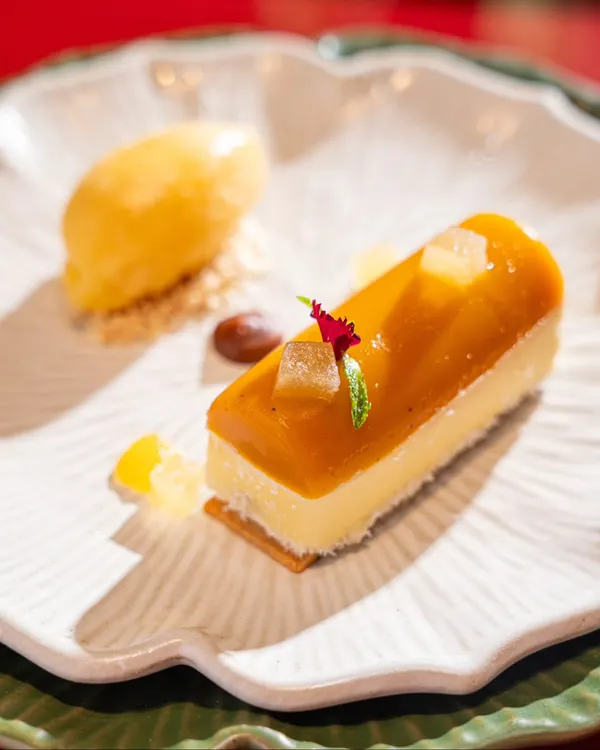 A beautiful yuzu cheesecake dessert. This shot highlights our skill in plating and lighting for delicate and minimalist desserts.