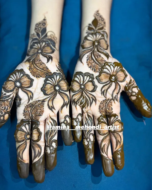 A unique and modern mehendi design featuring beautiful, intricate bows as the main pattern on the back of the hands.