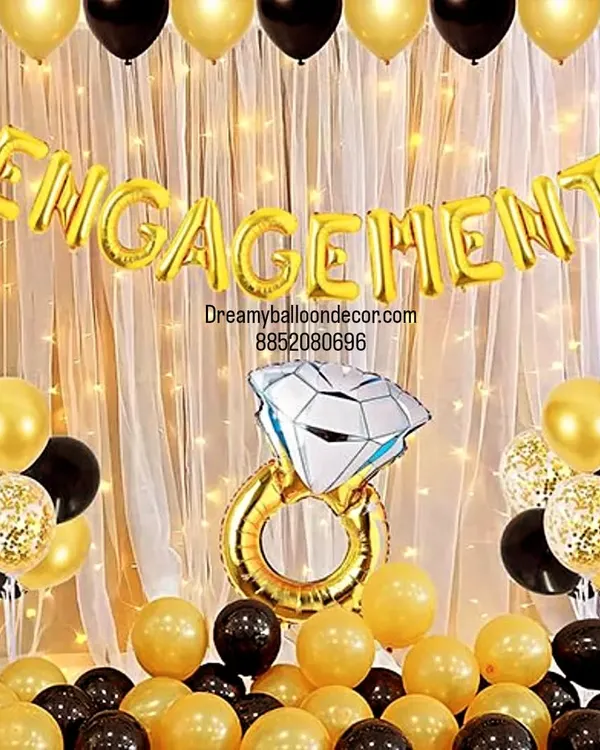 A classic and elegant engagement party backdrop. The black and gold theme, 'Engagement' foil banner, and giant ring prop create a perfect photo corner for you and your guests.