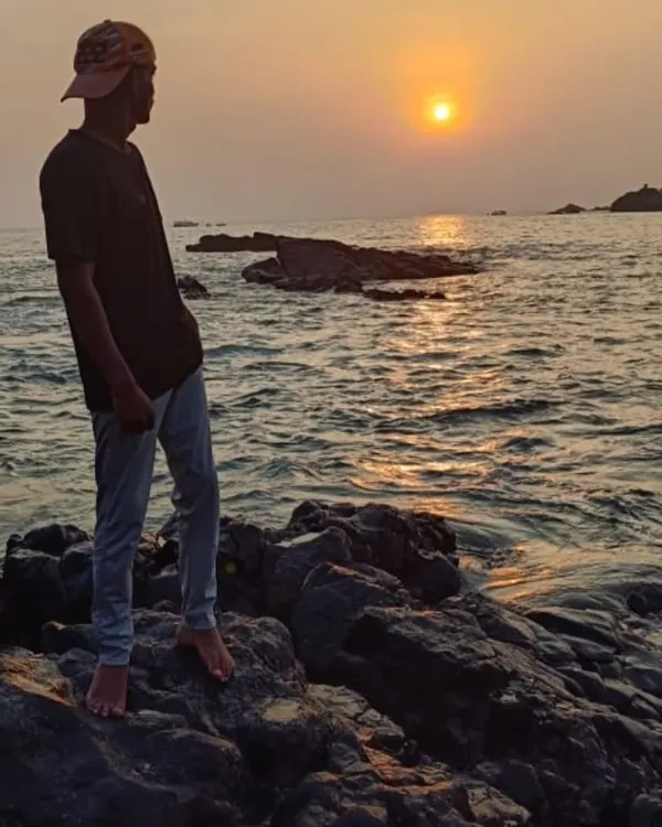 A trekker watching a beautiful sunset over the Arabian Sea. These are the peaceful moments our coastal trek offers.