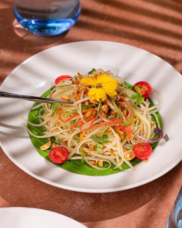 A beautifully plated papaya salad for a restaurant shoot. My styling focused on the delicate arrangement of ingredients, garnished with an edible flower, to present the dish as a light, fresh, and gourmet option.