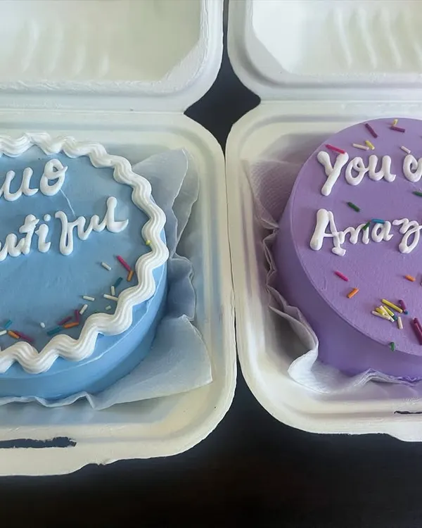 Two of our custom bento cakes with uplifting messages, "Hello Beautiful" and "You Are Amazing." These mini cakes are perfect for gifting and spreading joy.