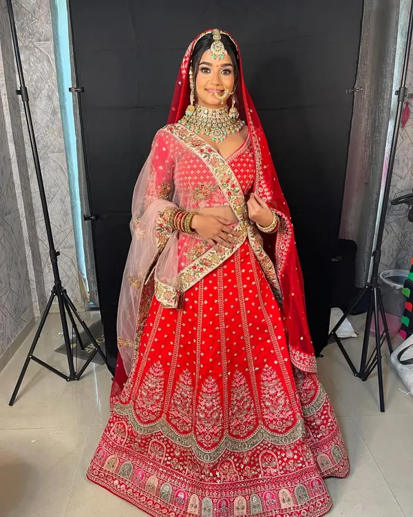 This is the quintessential red bridal lehenga, perfect for your big day. The intricate embroidery and classic design make it a timeless choice for any bride wanting to feel like royalty.